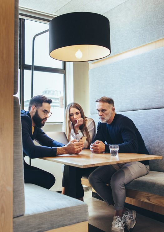 Employees Reading a Phone in a Booth